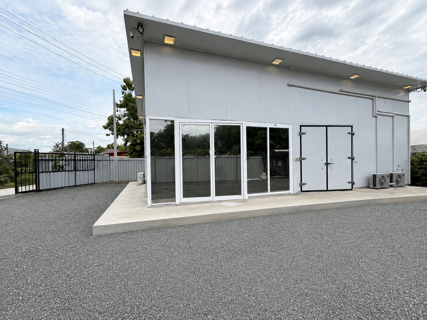 Finished modular sandwich-panel building in Thailand, exterior view with glass doors
