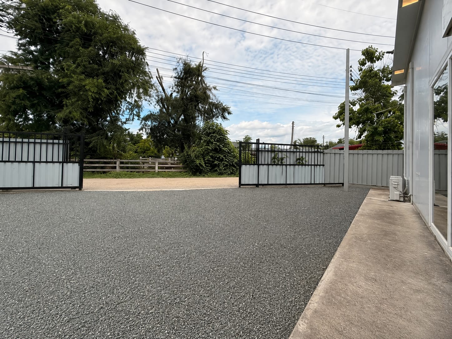 Exterior gravel yard and gate beside the building